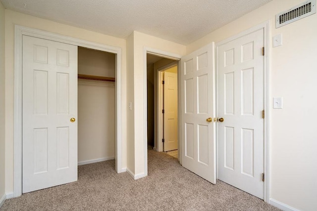 129 Fisherville Rd Unit 26, Concord, NH 03303 - unfurnished bedroom featuring light colored carpet, a closet, and a textured ceiling