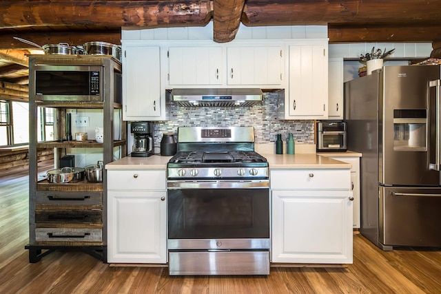 30 W Rd, Hubbardton, VT 05743 - kitchen featuring appliances with stainless steel finishes, exhaust hood, light countertops, tasteful backsplash, and wood finished floors