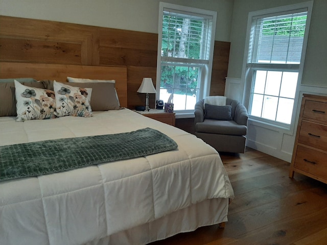 11 Captain Lovewell Ln, Ossipee, NH 03814 - bedroom featuring wood finished floors, a wainscoted wall, and a decorative wall