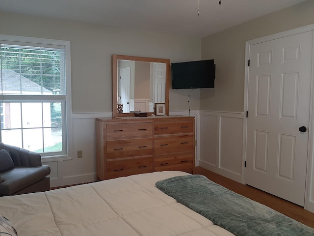 11 Captain Lovewell Ln, Ossipee, NH 03814 - bedroom featuring a wainscoted wall, a decorative wall, and wood finished floors