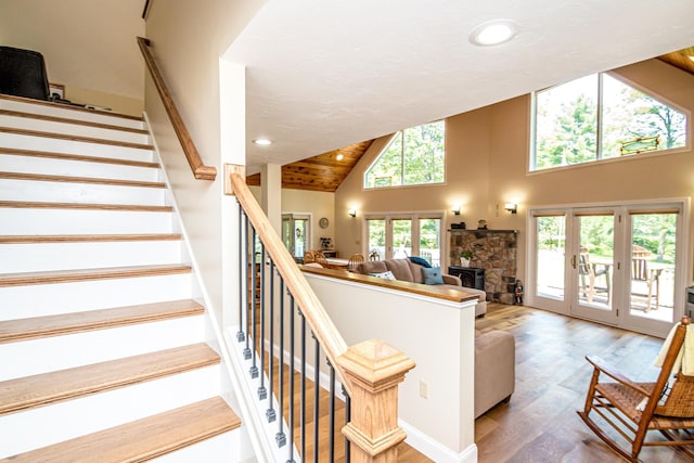 11 Captain Lovewell Ln, Ossipee, NH 03814 - stairway featuring wood finished floors, high vaulted ceiling, recessed lighting, a stone fireplace, and french doors