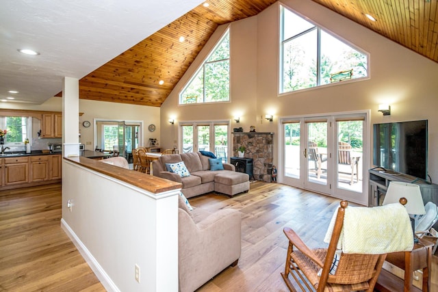 11 Captain Lovewell Ln, Ossipee, NH 03814 - living area featuring high vaulted ceiling, light wood finished floors, a stone fireplace, and wood ceiling