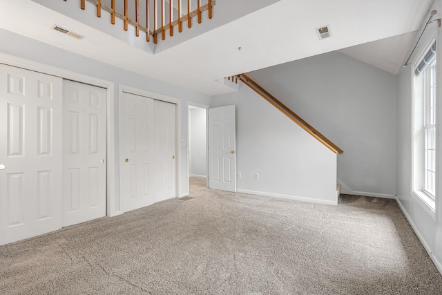 33 Beech Hill Ave, Manchester, NH 03103 - unfurnished living room with carpet flooring, stairs, and high vaulted ceiling
