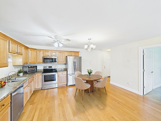6 Stearns Ln Unit 103, Merrimack, NH 03054 - kitchen with appliances with stainless steel finishes, light wood-type flooring, a chandelier, and dark stone counters