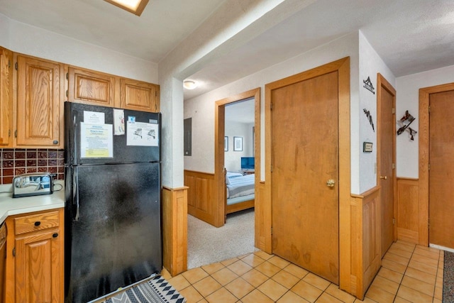 F22 Christmas Mountain Rd Unit 22, Bartlett, NH 03812 - kitchen with freestanding refrigerator, light tile patterned floors, a wainscoted wall, light countertops, and backsplash