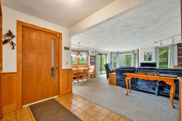 F22 Christmas Mountain Rd Unit 22, Bartlett, NH 03812 - entrance foyer featuring a textured ceiling, light tile patterned flooring, light colored carpet, and a wainscoted wall