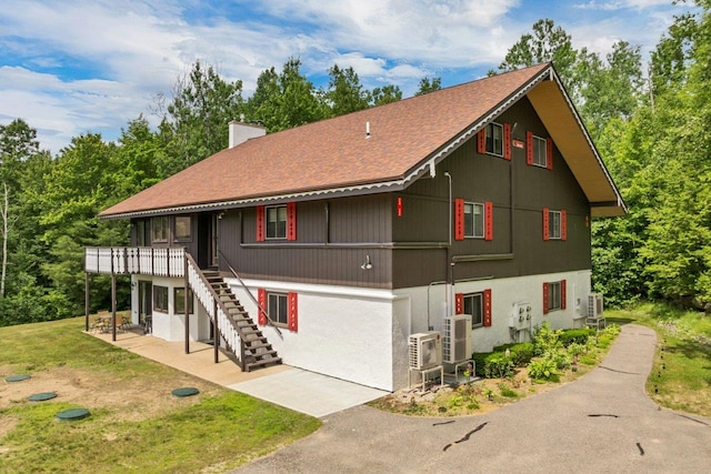 F22 Christmas Mountain Rd Unit 22, Bartlett, NH 03812 - view of front facade with a chimney, a patio, a front lawn, stairway, and roof with shingles