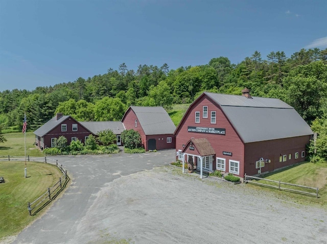 3247 Rte 302, Lisbon, NH 03585 - view of front of house featuring a gambrel roof, asphalt driveway, a garage, a chimney, and a view of trees