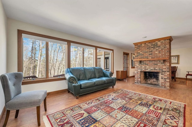 107 Peaked Hill Rd, Hopkinton, NH 03229 - living room featuring healthy amount of natural light, a brick fireplace, and wood finished floors