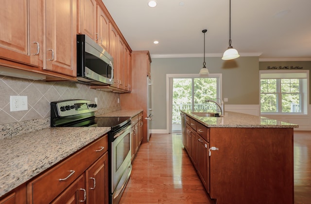 2C Manor Dr, Hooksett, NH 03106 - kitchen featuring stainless steel appliances, light wood-style flooring, light stone counters, plenty of natural light, and crown molding