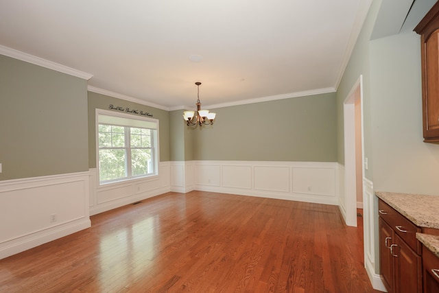 2C Manor Dr, Hooksett, NH 03106 - unfurnished dining area with a chandelier, wood finished floors, wainscoting, and crown molding