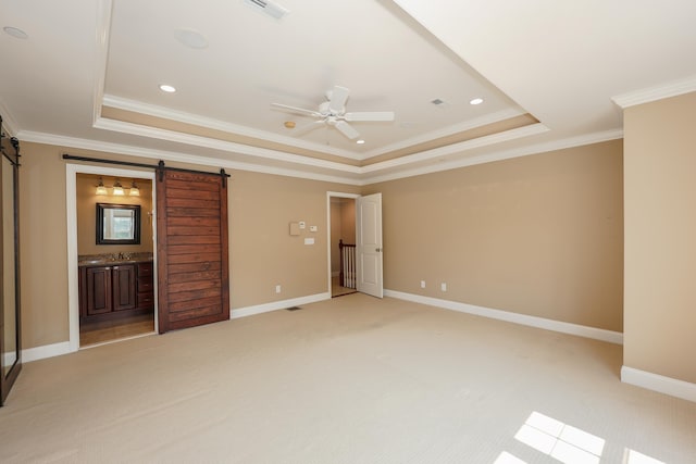 2C Manor Dr, Hooksett, NH 03106 - unfurnished bedroom featuring a barn door, a raised ceiling, crown molding, light carpet, and recessed lighting