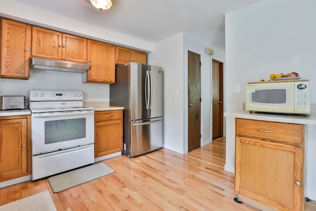 22 Pelham Rd, Hudson, NH 03051 - kitchen featuring white appliances, under cabinet range hood, light countertops, light wood-style flooring, and brown cabinets