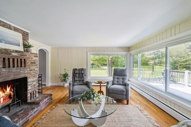 626 County Rd, New London, NH 03257 - living area with a baseboard radiator, a fireplace, wood finished floors, and arched walkways