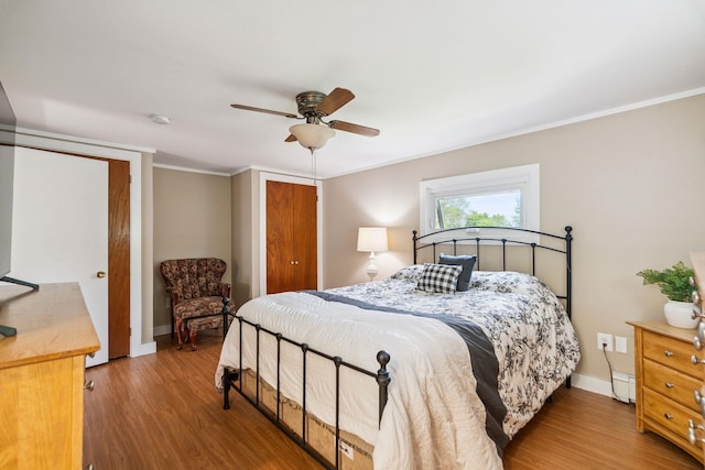 626 County Rd, New London, NH 03257 - bedroom featuring a baseboard heating unit, wood finished floors, ornamental molding, and ceiling fan