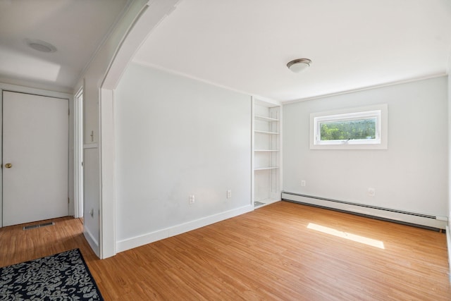 626 County Rd, New London, NH 03257 - spare room with a baseboard radiator, wood finished floors, built in features, and arched walkways
