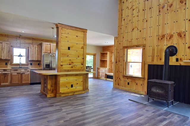 00 Serenity Ln, Lisbon, NH 03585 - kitchen with stainless steel appliances, a wood stove, light countertops, dark wood-style flooring, and wooden walls