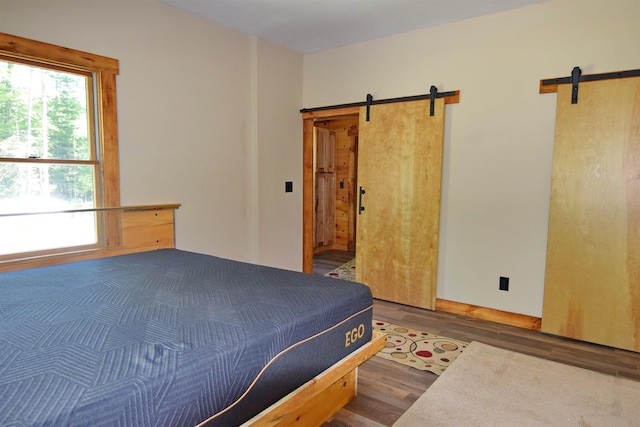 00 Serenity Ln, Lisbon, NH 03585 - bedroom featuring a barn door and wood finished floors