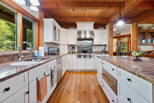 82 Little Cove Rd, New London, NH 03257 - kitchen featuring wall chimney exhaust hood, healthy amount of natural light, light wood finished floors, stainless steel dishwasher, and a wooden ceiling with exposed beams