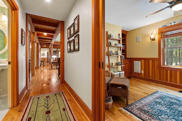 82 Little Cove Rd, New London, NH 03257 - corridor with light wood-type flooring, wainscoting, and beamed ceiling