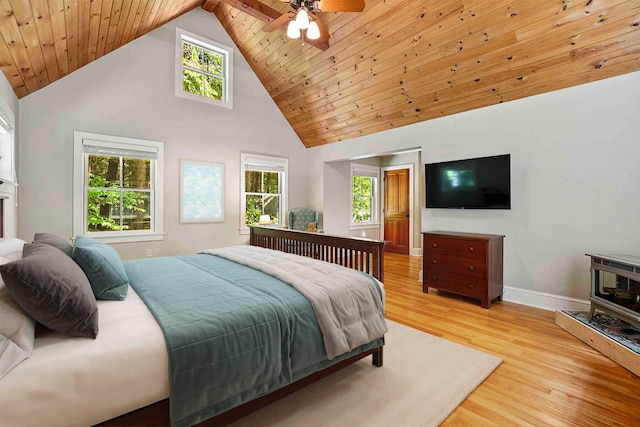 82 Little Cove Rd, New London, NH 03257 - bedroom with high vaulted ceiling, light wood-type flooring, a wood stove, and a ceiling fan