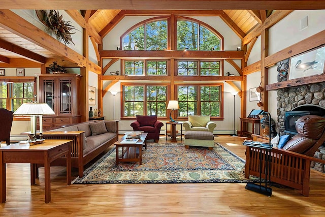 82 Little Cove Rd, New London, NH 03257 - living area with hardwood / wood-style flooring, high vaulted ceiling, a baseboard heating unit, a fireplace, and a baseboard radiator