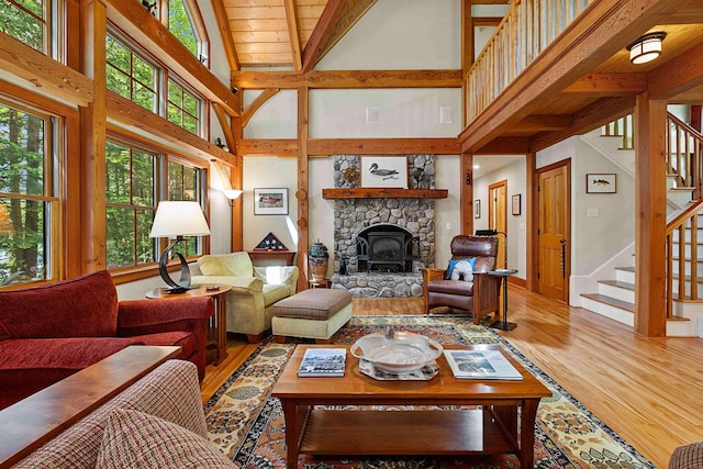 82 Little Cove Rd, New London, NH 03257 - living room with high vaulted ceiling, light wood-style flooring, stairs, beamed ceiling, and a stone fireplace