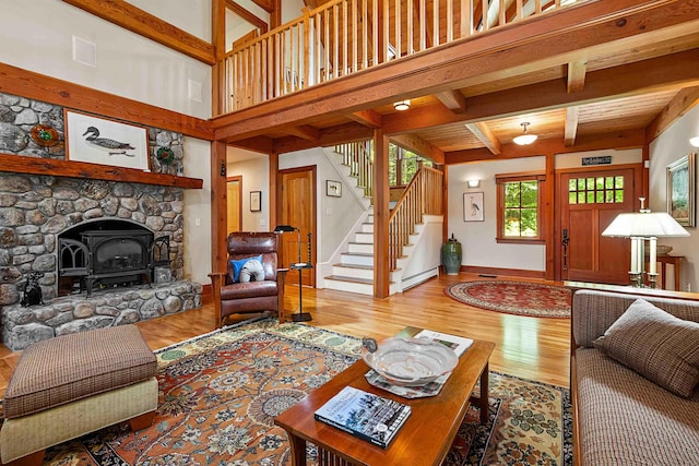 82 Little Cove Rd, New London, NH 03257 - living area with a baseboard heating unit, wood finished floors, stairway, a wood stove, and beamed ceiling