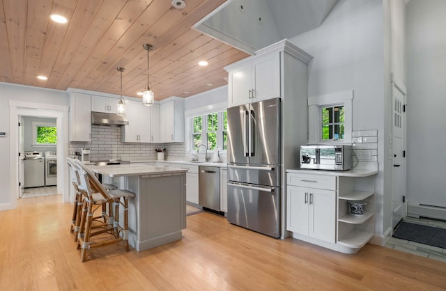 184 Bowles Rd, Newbury, NH 03855 - kitchen featuring appliances with stainless steel finishes, separate washer and dryer, under cabinet range hood, light wood-style flooring, and wooden ceiling