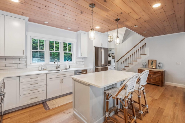184 Bowles Rd, Newbury, NH 03855 - kitchen with stainless steel appliances, wooden ceiling, white cabinets, light countertops, and a breakfast bar