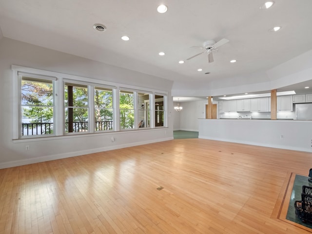 432 Shore Dr, Laconia, NH 03246 - unfurnished living room featuring healthy amount of natural light, ceiling fan, recessed lighting, light wood finished floors, and a chandelier