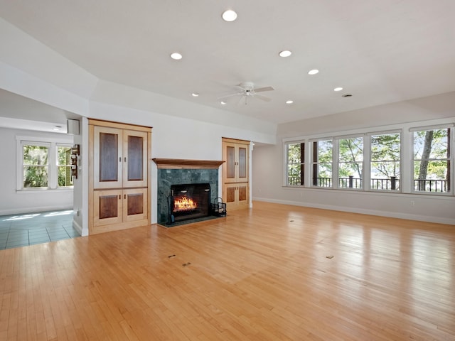 432 Shore Dr, Laconia, NH 03246 - unfurnished living room featuring ceiling fan, light wood finished floors, a fireplace, recessed lighting, and plenty of natural light