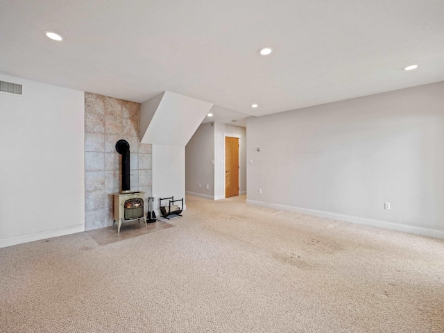 432 Shore Dr, Laconia, NH 03246 - unfurnished living room featuring recessed lighting, a wood stove, and carpet flooring