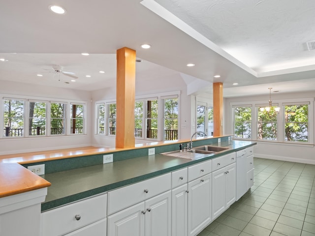 432 Shore Dr, Laconia, NH 03246 - kitchen featuring light tile patterned floors, healthy amount of natural light, recessed lighting, white cabinets, and dark countertops