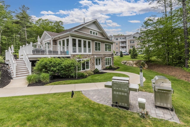 32 Willey Creek Rd Unit 402, Exeter, NH 03833 - view of front of property with stone siding, a wooden deck, a front yard, stairs, and a standing seam roof