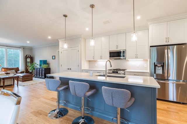 32 Willey Creek Rd Unit 402, Exeter, NH 03833 - kitchen with stainless steel appliances, decorative backsplash, a kitchen breakfast bar, light countertops, and ornamental molding