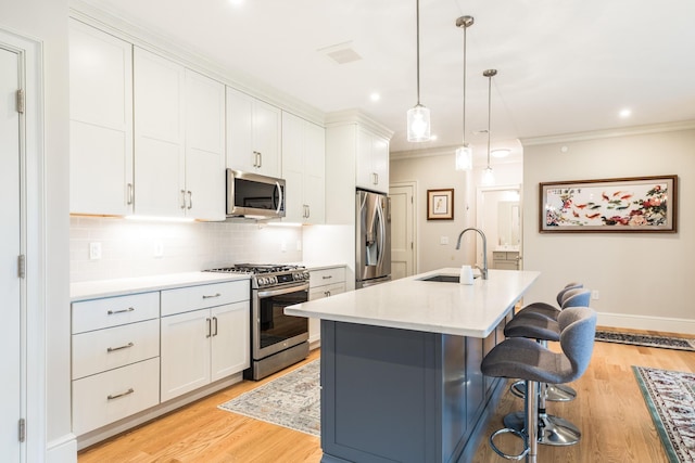 32 Willey Creek Rd Unit 402, Exeter, NH 03833 - kitchen featuring stainless steel appliances, light countertops, tasteful backsplash, a kitchen bar, and white cabinetry