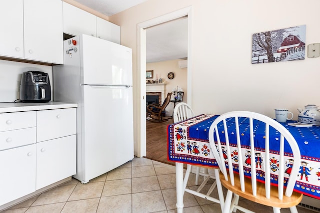 39 Hilltop Pl Unit 39, New London, NH 03257 - dining space featuring light tile patterned floors, a fireplace, and a wall mounted air conditioner