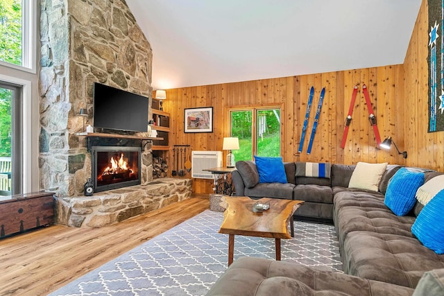 E12 Rock Ridge Rd, Winhall, VT 05340 - living area with lofted ceiling, wood finished floors, wooden walls, a fireplace, and heating unit