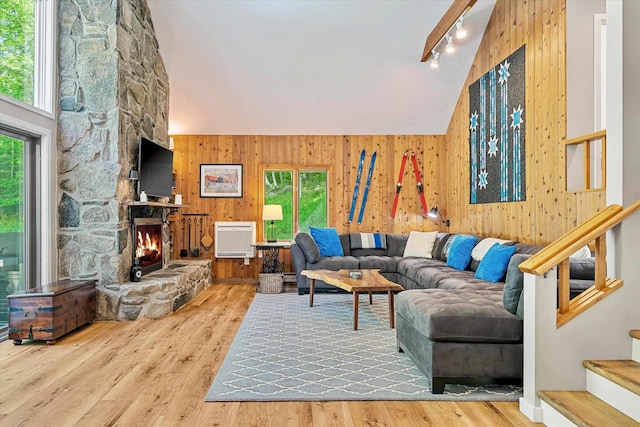 E12 Rock Ridge Rd, Winhall, VT 05340 - living room featuring rail lighting, wood walls, plenty of natural light, stairway, and a stone fireplace