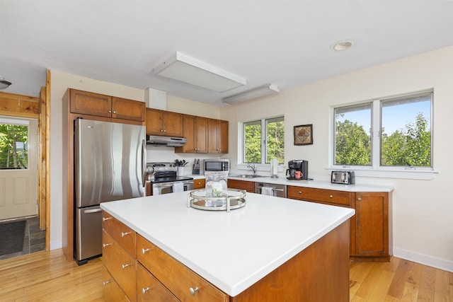 719 Roundabout Rd, Killington, VT 05751 - kitchen with stainless steel appliances, under cabinet range hood, light wood-style flooring, a center island, and light countertops