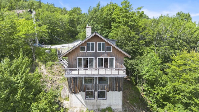 719 Roundabout Rd, Killington, VT 05751 - rear view of property featuring stairs, a view of trees, and a chimney