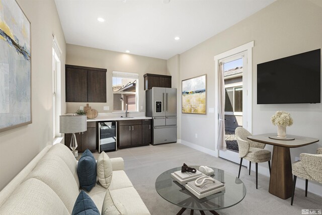 9093 Wild Skies Way, Reno, NV 89523 - living room with light colored carpet, recessed lighting, wine cooler, baseboards, and bar area