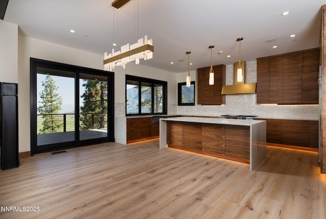 200 Overlook Dr Unit 29, Carson City, NV 89705 - kitchen with modern cabinets, wall chimney exhaust hood, brown cabinets, light wood-style floors, and light countertops