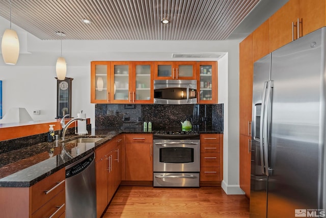 255 N Sierra St Unit 2013, Reno, NV 89501 - kitchen with appliances with stainless steel finishes, a sink, a peninsula, light wood finished floors, and brown cabinetry