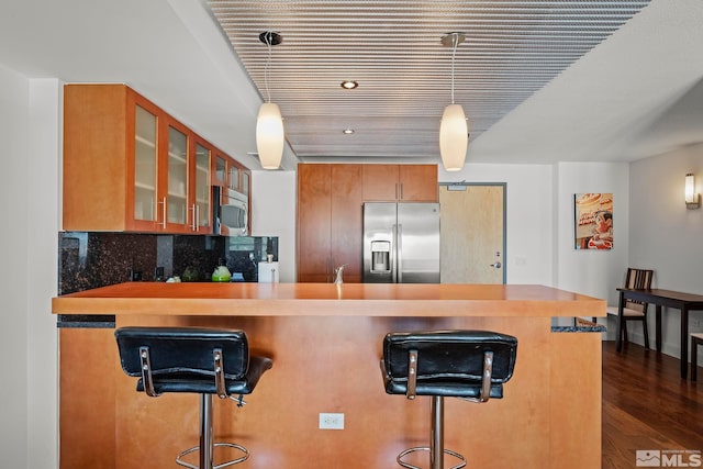 255 N Sierra St Unit 2013, Reno, NV 89501 - kitchen with stainless steel appliances, glass insert cabinets, brown cabinets, dark wood-style floors, and a kitchen breakfast bar
