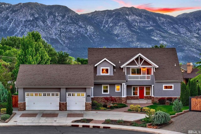 1008 Keystone Ct, Gardnerville, NV 89460 - view of front of house with a balcony, a mountain view, driveway, a garage, and stone siding