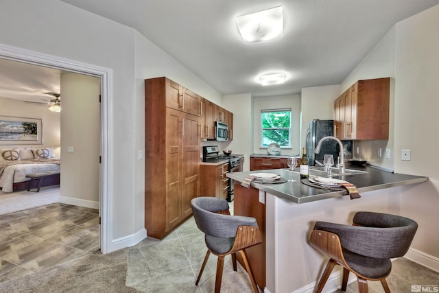 1008 Keystone Ct, Gardnerville, NV 89460 - kitchen with stainless steel appliances, a sink, a breakfast bar, and brown cabinetry