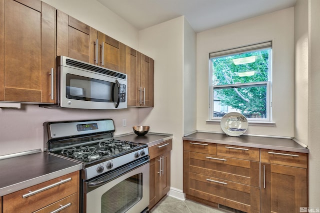 1008 Keystone Ct, Gardnerville, NV 89460 - kitchen featuring appliances with stainless steel finishes, stainless steel counters, light tile patterned floors, and brown cabinets