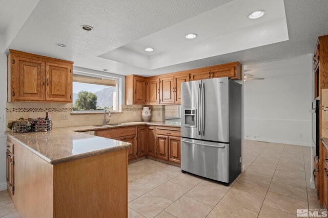 1663 Mackland Dr, Minden, NV 89423 - kitchen featuring stainless steel refrigerator with ice dispenser, a sink, a raised ceiling, tasteful backsplash, and a peninsula